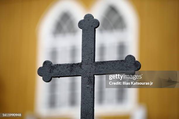 religious cross with yellow church defocused on background - orthodox stock pictures, royalty-free photos & images