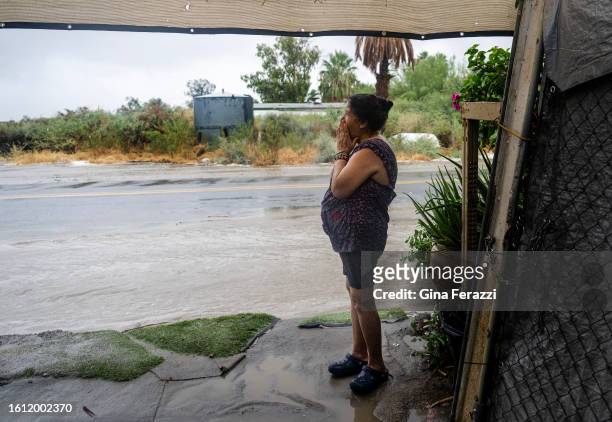 Maria Elena Zaragoza of Thermal watches as heavy rains push flood waters towards her driveway as tropical storm Hilary dumps torrential rain on the...