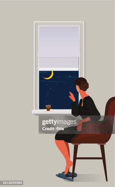 a woman in a long black dress sitting by the window and looking at the night of a crescent moon outside the window - chin stock illustrations