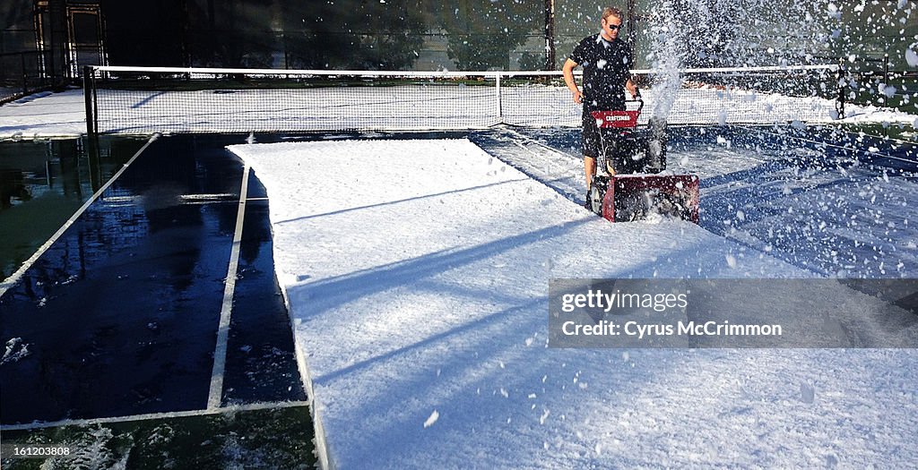 Avid tennis player Kyle Fletcher goes to the snow blower to help clear the tennis courts at Washington Park on Monday, February 13, 2012. Cyrus McCrimmon, The Denver Post