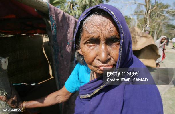 Years-old Bangladeshi cyclone affected woman Chan Banu stands in front of her makeshift shelter beside a road in Gorjonbunia village on the southern...