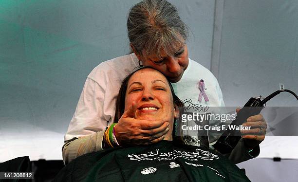Harriet Carmine comforts her daughter Robyn Carmine while shaving her head to support childhood cancer research on behalf of the St. Baldrick's...