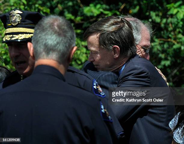 Governor John Hickenlooper, right, pauses and hugs Aurora Mayor Steve Hogan outside the church at the end of the service. Funeral service for AJ Boik...