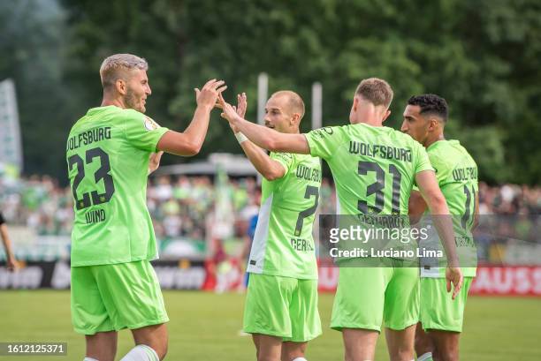 Yannick Gerhardt of VfL Wolfsburg celebrates with teammates after scoring his team's fourth goal during the DFB cup first round match between TuS...