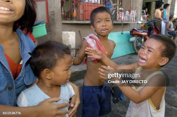 Teresa Quadro comforts her three brothers as they cry in the eastern Philippine village of Rawis, Legazpi after a rumour spread that a tsunami was...