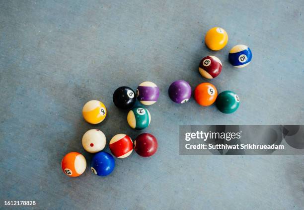 direct above of multi colored pool balls on old pool table - queue stock-fotos und bilder