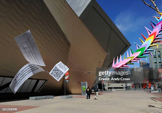 Paper cubes with QR codes and flyers attached to it flies in the breeze in front of the Denver Art Museum Tuesday morning. The cubes were part of a...