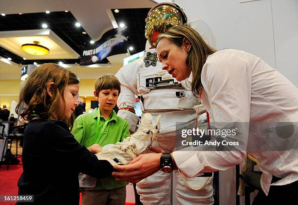 S Strategic Communications Lead Crew and Thermal Systems division, Heather Paul, right, fits Charlotte Commons, 7-years-old, with a glove insert from...