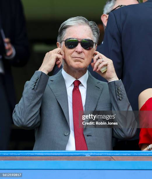 Liverpool owner John W Henry checks his ear plugs are in place before the Premier League match between Chelsea FC and Liverpool FC at Stamford Bridge...