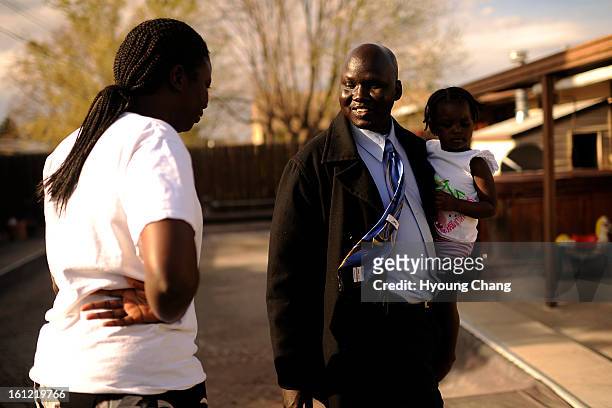 Sudan lost boy Gatbel Chamjock who holding his daughter Naken Gatbel, is talking with his wife Nyamission Jock after his work at their house in...