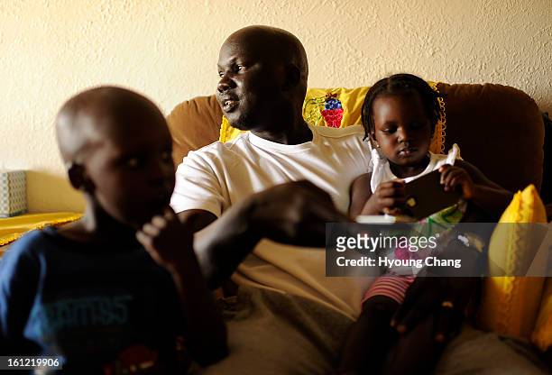Sudan lost boy Gatbel Chamjock center, spends time with his son Tethloach Gatbel, age 3, and daughter Nyaken Gatbel, age 1, at their house in...