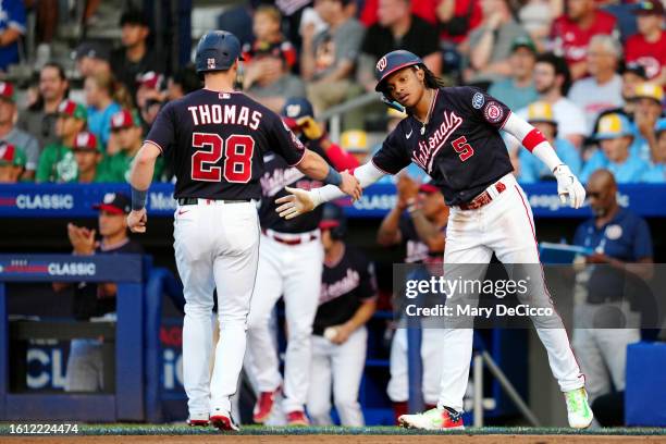 Lane Thomas of the Washington Nationals is greeted by teammate CJ Abrams after scoring a run during the 2023 Little League Classic between the...