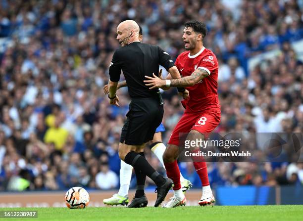 Dominik Szoboszlai of Liverpool reacts to an obstruction by Referee Anthony Taylor during the Premier League match between Chelsea FC and Liverpool...