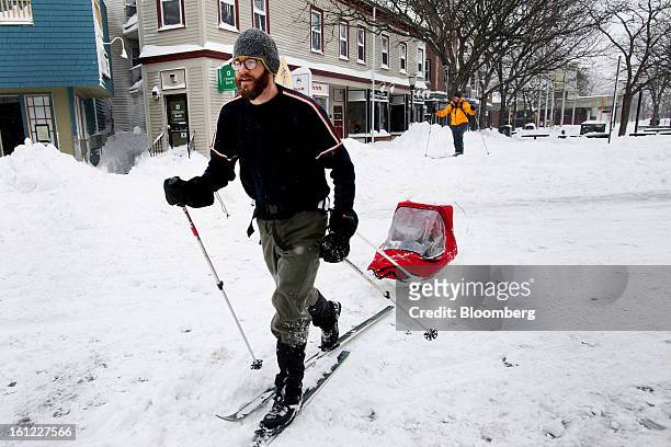 Resident Brian Postlewaite tows his son, Fraser Postlewaite across Holland Street after Winter Storm Nemo in Somerville, Massachusetts, U.S., on...
