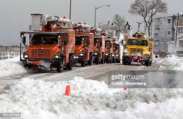Utility trucks sit idle along Winthrop Shore Drive after Winter Storm Nemo in Winthrop, Massachusetts, U.S., on Saturday, Feb. 9, 2013. More than two...