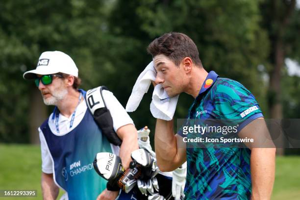 Golfer Viktor Hovland towels off his face while walking the 6th hole during the final round of the BMW Championship Fed Ex Cup Playoffs on August...