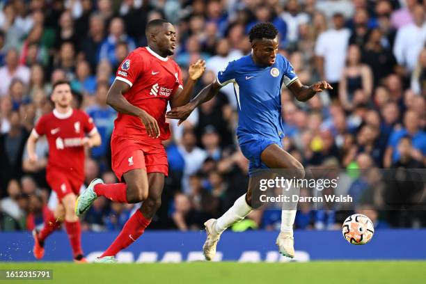 Nicolas Jackson of Chelsea runs with the ball whilst under pressure from Ibrahima Konate of Liverpool during the Premier League match between Chelsea...