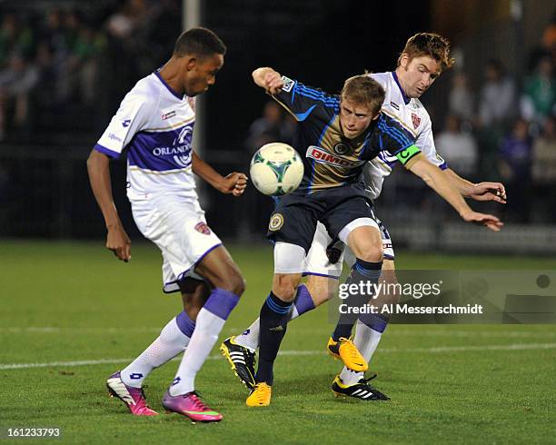 Forward Dennis Chin of Orlando City battles midfielder Brian Carroll of the Philadelphia Union February 9, 2013 in the first round of the Disney Pro...
