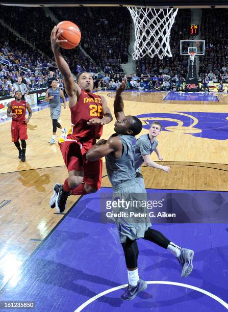 Guard Tyrus McGee of the Iowa State Cyclones drives to the basket against guard Martavious Irving of the Kansas State Wildcats during the second half...