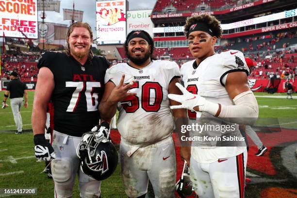 Kaleb McGary of the Atlanta Falcons poses for a photo with Vita Vea and Joe Tryon-Shoyinka of the Tampa Bay Buccaneers after an NFL game at Raymond...