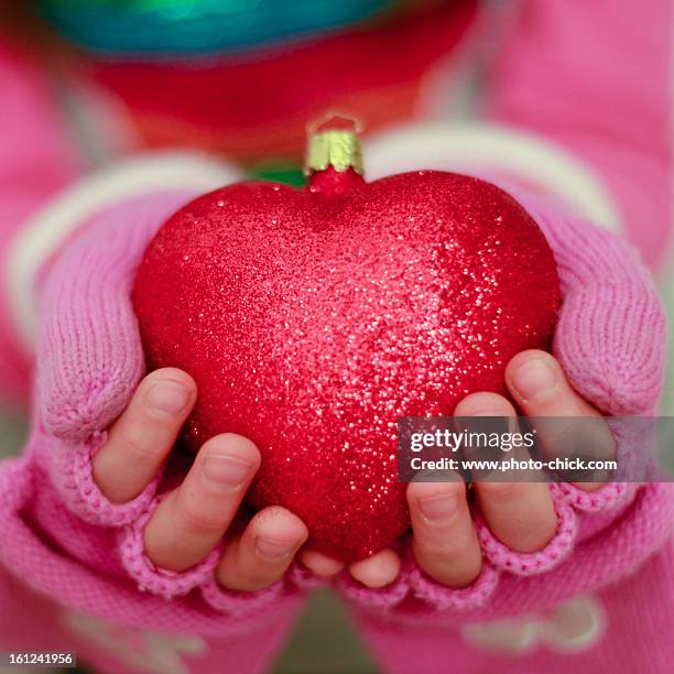 girl holding a glittery red heart ornament - zurich christmas stock pictures, royalty-free photos & images