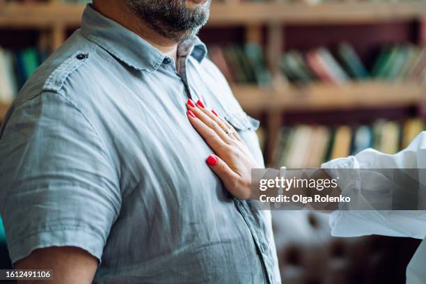 stop word, learn to deny on psychotherapy session. unrecognizable bearded man with woman hand on his chest against blurred bookcase - emotional support stock pictures, royalty-free photos & images