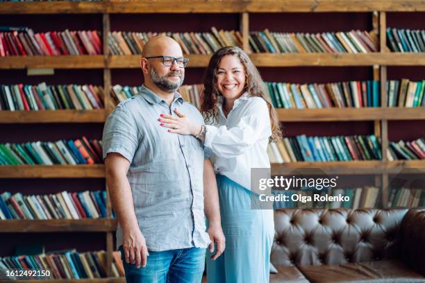 low self esteem and mental illness solutions with mentor. bald bearded man in eyeglasses with woman hand on his chest in doctor office - hand on female chest stock pictures, royalty-free photos & images