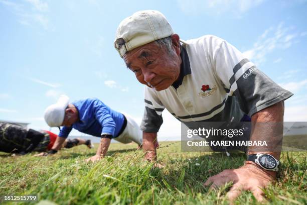 This photo taken on June 28, 2023 shows 85 year old player Yasutake Oshima from the Fuwaku rugby club doing push-ups as he takes part in a rugby...