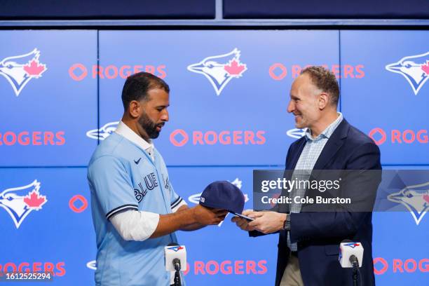 Former Toronto Blue Jay José Bautista is given a hat from Toronto Blue Jays president Mark Shapiro after signing a one-day contract with the club, at...