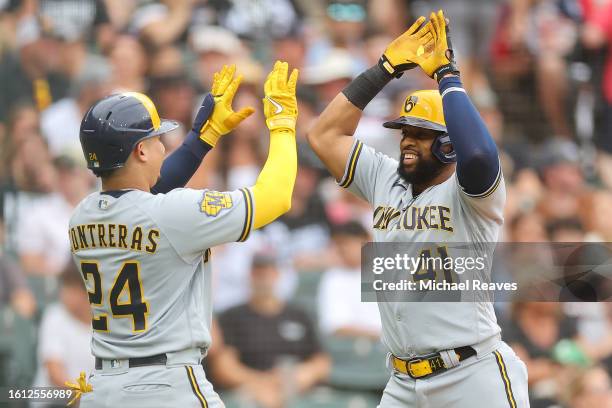 Carlos Santana of the Milwaukee Brewers high fives William Contreras after hitting a three-run home run off Aaron Bummer of the Chicago White Sox...