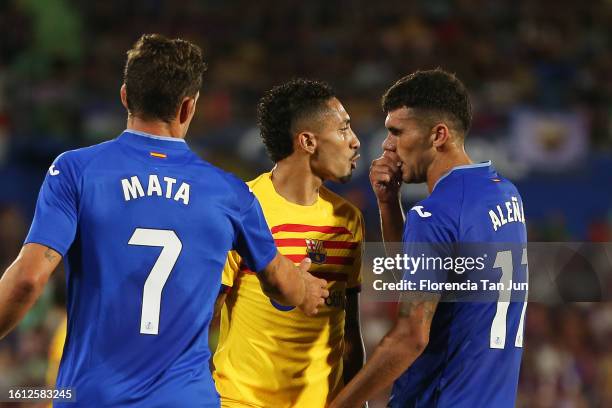 Raphinha of FC Barcelona and Carles Alena of Getafe CF clash during the LaLiga EA Sports match between Getafe CF and FC Barcelona at Coliseum Alfonso...