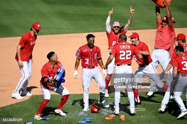 Jeter Downs of the Washington Nationals celebrates with teammates after driving in the game winning run in the ninth inning against the Oakland...