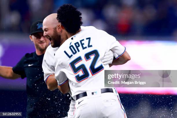 Jake Burger of the Miami Marlins celebrates with teammates after walking it off to defeat the New York Yankees at loanDepot park on August 13, 2023...