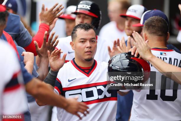 Carlos Perez of the Chicago White Sox high fives teammates after scoring a run during the ninth inning against the Milwaukee Brewers at Guaranteed...