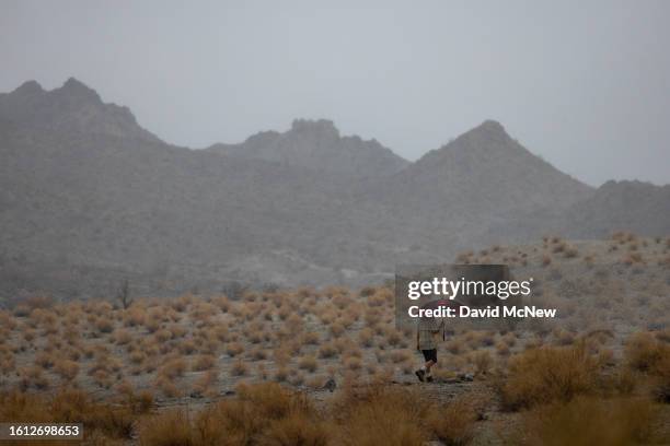 Man walks a desert hiking trail in the rain from Tropical Storm Hilary in Southern California on August 20, 2023 near La Quinta, California. More...