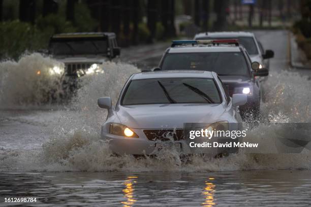 Motorists ford a roadway flooded by Tropical Storm Hilary in the deserts of Southern California on August 20, 2023 in La Quinta, California. More...