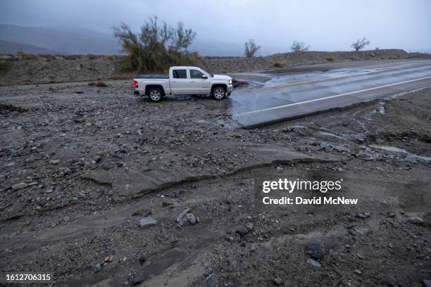 Motorist negotiates a road covered with rocks left behind in a flash flood from Tropical Storm Hilary in the deserts of Southern California on August...