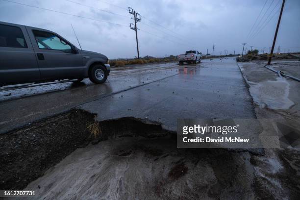 Motorists navigate a road damaged by a flash flood from Tropical Storm Hilary in the deserts of Southern California on August 20, 2023 near Indio,...