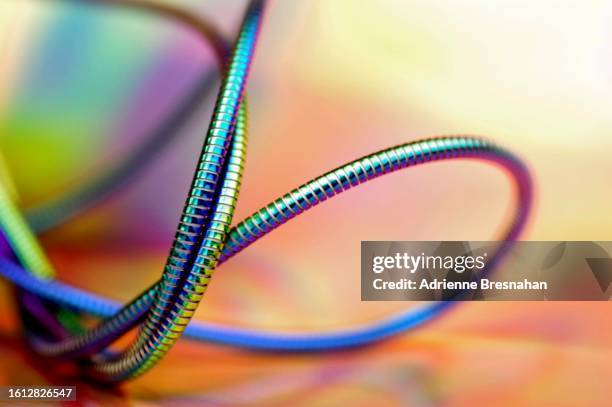 twisted and coiled metallic cable - tangle stock pictures, royalty-free photos & images