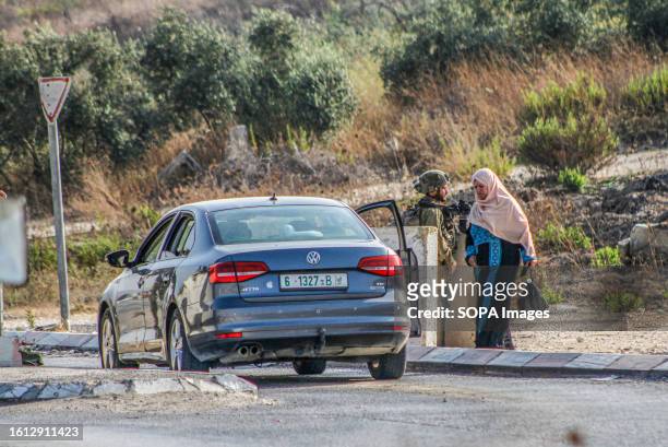 Israeli soldiers search a Palestinian woman's car during intensive operations to search for the attacker who shot at two Jewish settlers in the...