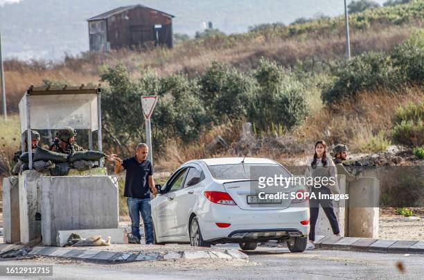 Israeli soldiers search a car of Palestinians during intensive operations to search for the attacker who shot at two Jewish settlers in the...