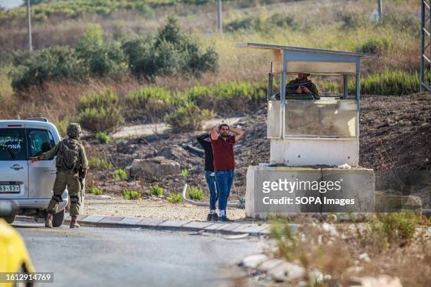 Palestinians putting their hands on top of their head are seen as Israeli soldiers searching their car during intensive operations to search for the...