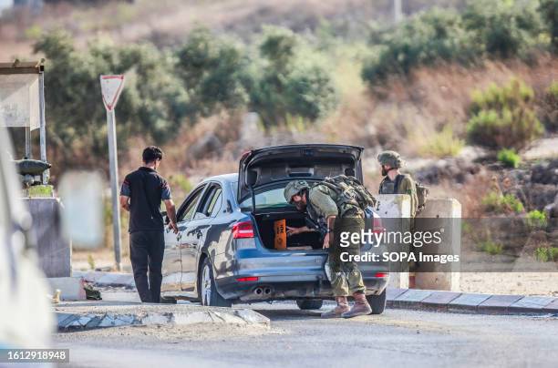 An Israeli soldier search a car during intensive operations to search for the attacker who shot at two Jewish settlers in the Palestinian town of...
