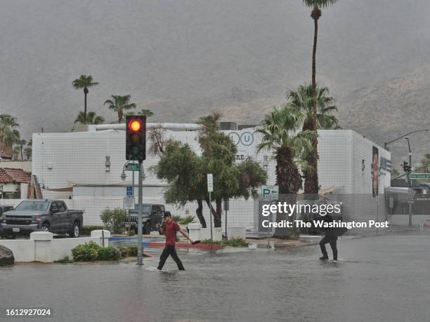 August 20: People walk through the flooded streets of downtown Palm Springs, California on August 20, 2023. Southern California is under a tropical...