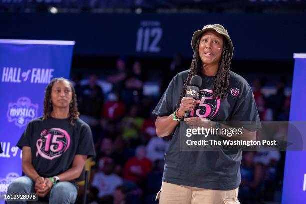 Chamique Holdsclaw speaks as Murriel Page looks on during a halftime ceremony posthumously inducting former Mystics player Nikki McCray-Penson into...