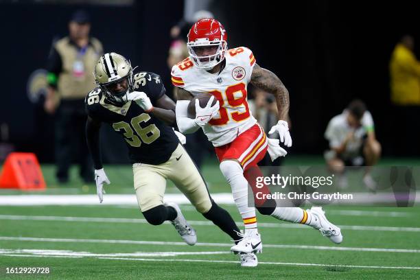 Kekoa Crawford of the Kansas City Chiefs is tackled by Anthony Johnson of the New Orleans Saints during a preseason game at Caesars Superdome on...