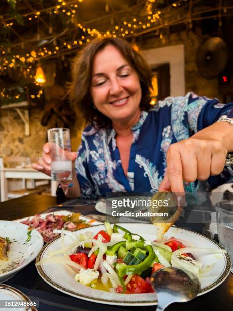 cheerful woman enjoying food and drink - ouzo stock pictures, royalty-free photos & images
