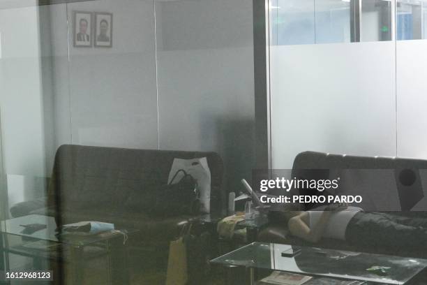 Man sleeps in a closed Air Koryo office in Beijing on August 21, 2023. North Korea's national airline was set to make its first commercial flight in...