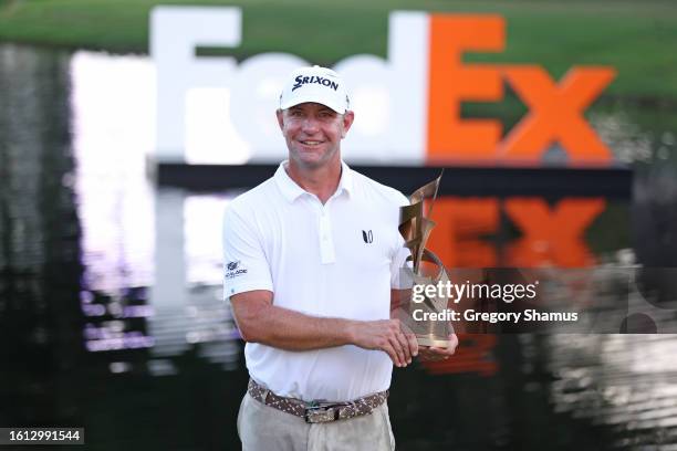 Lucas Glover of the United States poses with the trophy after putting in to win during the first playoff hole on the 18th green to win the tournament...