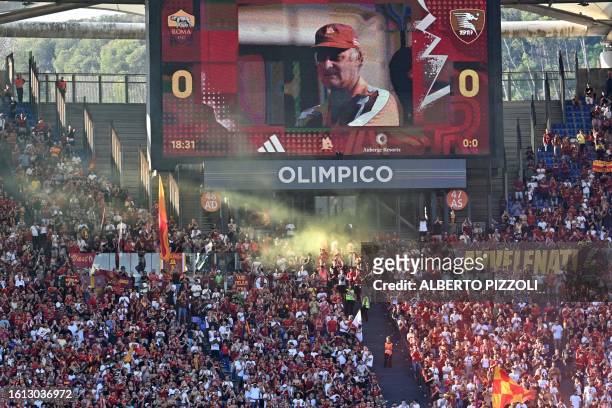 Giant screen displays a portrait of late headcoach Carlo Mazzone Rome's supporters cheer before the Italian Serie A football match Roma vs...